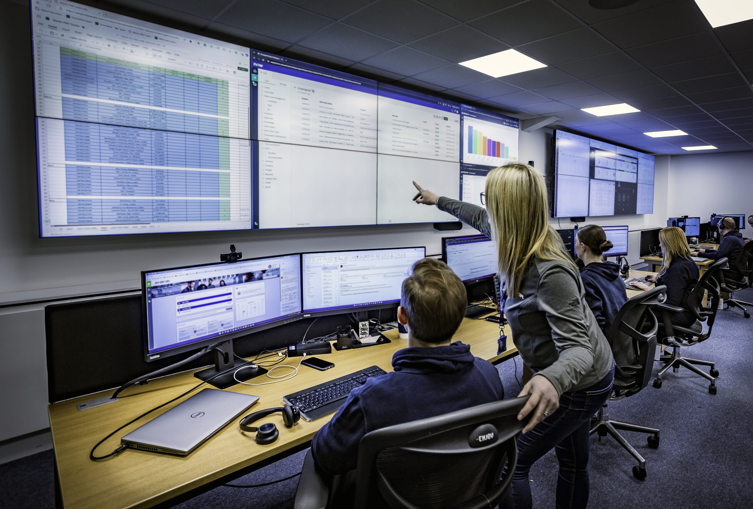 Engineering team reviewing technical data in a modern control room